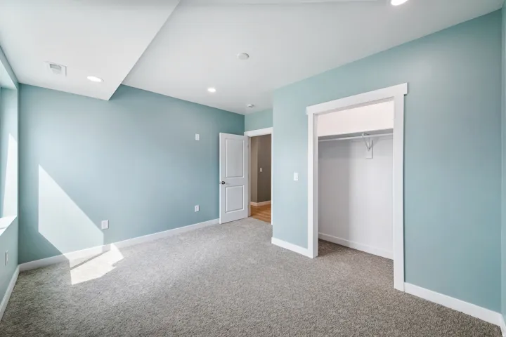 Wall-to-wall carpeting, recessed lighting, and a closet with hanging rod