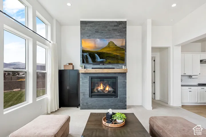 Stone-clad fireplace with a wood mantel, gas insert, and mounted display