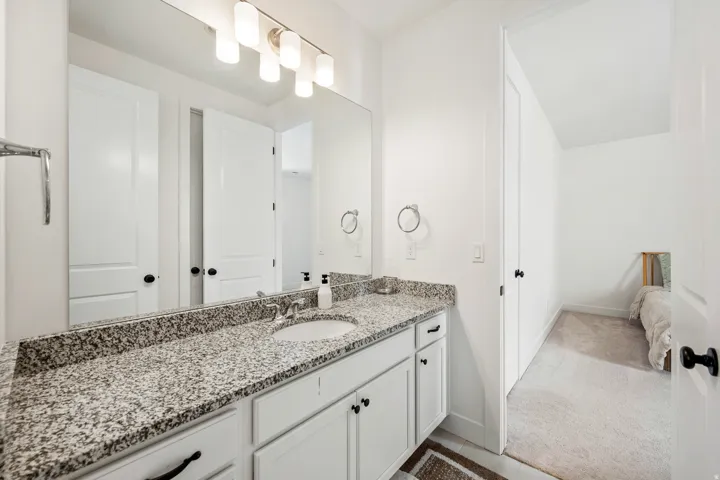 Vanity with granite countertop, undermount sink, and brushed nickel faucet