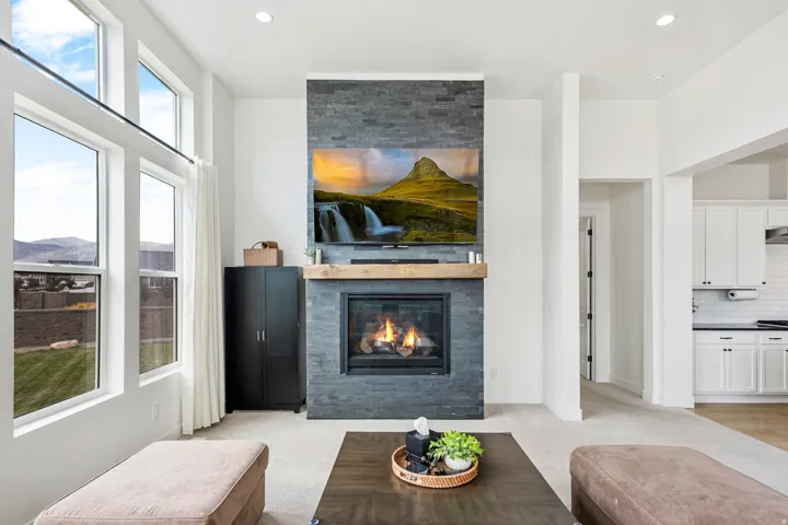 Stone-clad fireplace with a wood mantel, gas insert, and mounted display