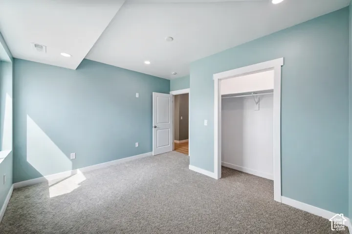 Wall-to-wall carpeting, recessed lighting, and a closet with hanging rod