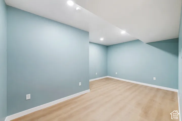 Recessed ceiling lighting, light wood-finish flooring, and light blue walls