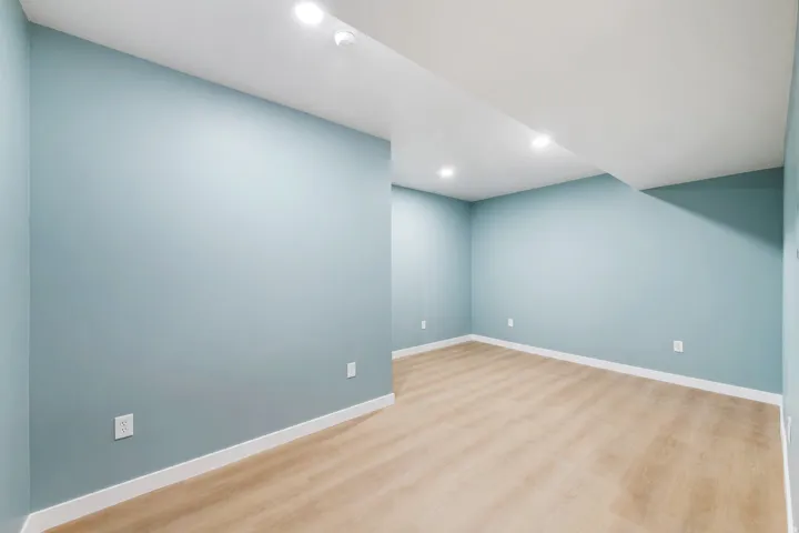 Recessed ceiling lighting, light wood-finish flooring, and light blue walls