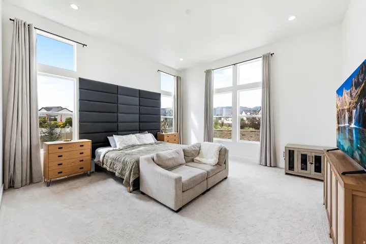 Recessed lighting, light-toned carpeting, high ceilings, and large windows with transom panels