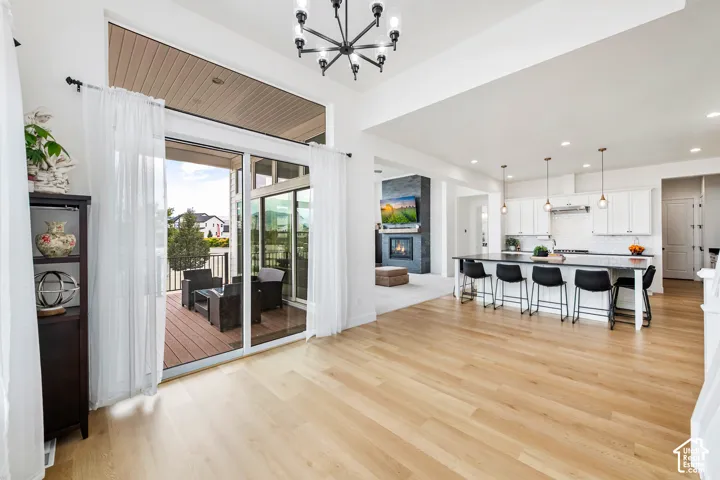 Spacious living area with wood-finish flooring, high ceilings, and a modern chandelier