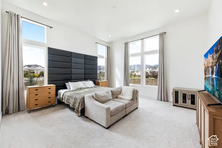 Recessed lighting, light-toned carpeting, high ceilings, and large windows with transom panels