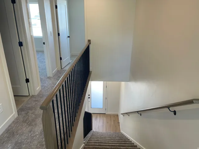 Upper level hallway with carpet flooring