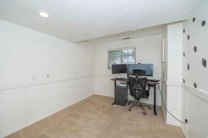 Basement carpeted bedroom with recessed lighting and a window featuring horizontal blinds