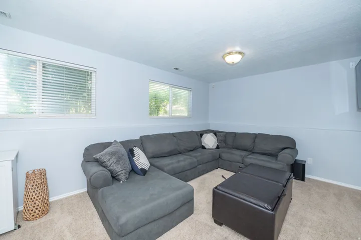 Wall-to-wall carpeting with multiple windows and a flush-mount ceiling light
