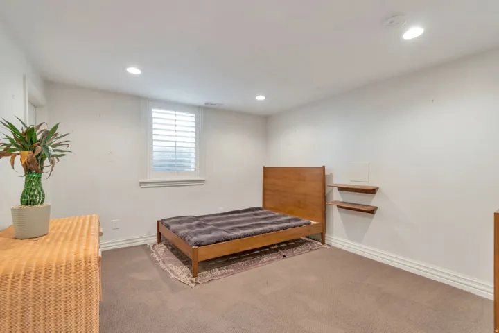 Recessed ceiling lighting, plantation shutters, wall-mounted shelving, and carpet flooring