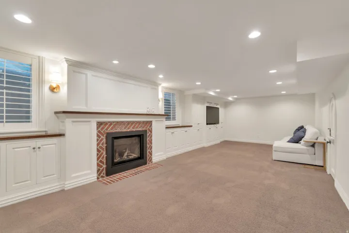 Built-in fireplace with a brick surround, white paneling, and wood-finish mantel