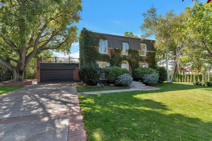 Brick exterior with extensive ivy coverage, a gray shingle mansard roof, and a prominent arched entry