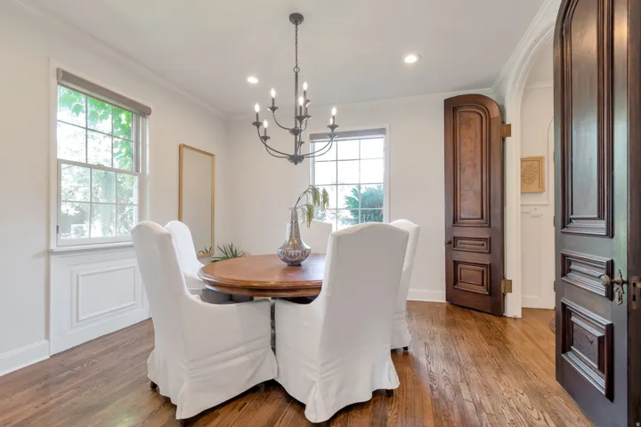 Hardwood flooring, elegant dark wood panel doors, crown molding, double-hung windows, and recessed lighting