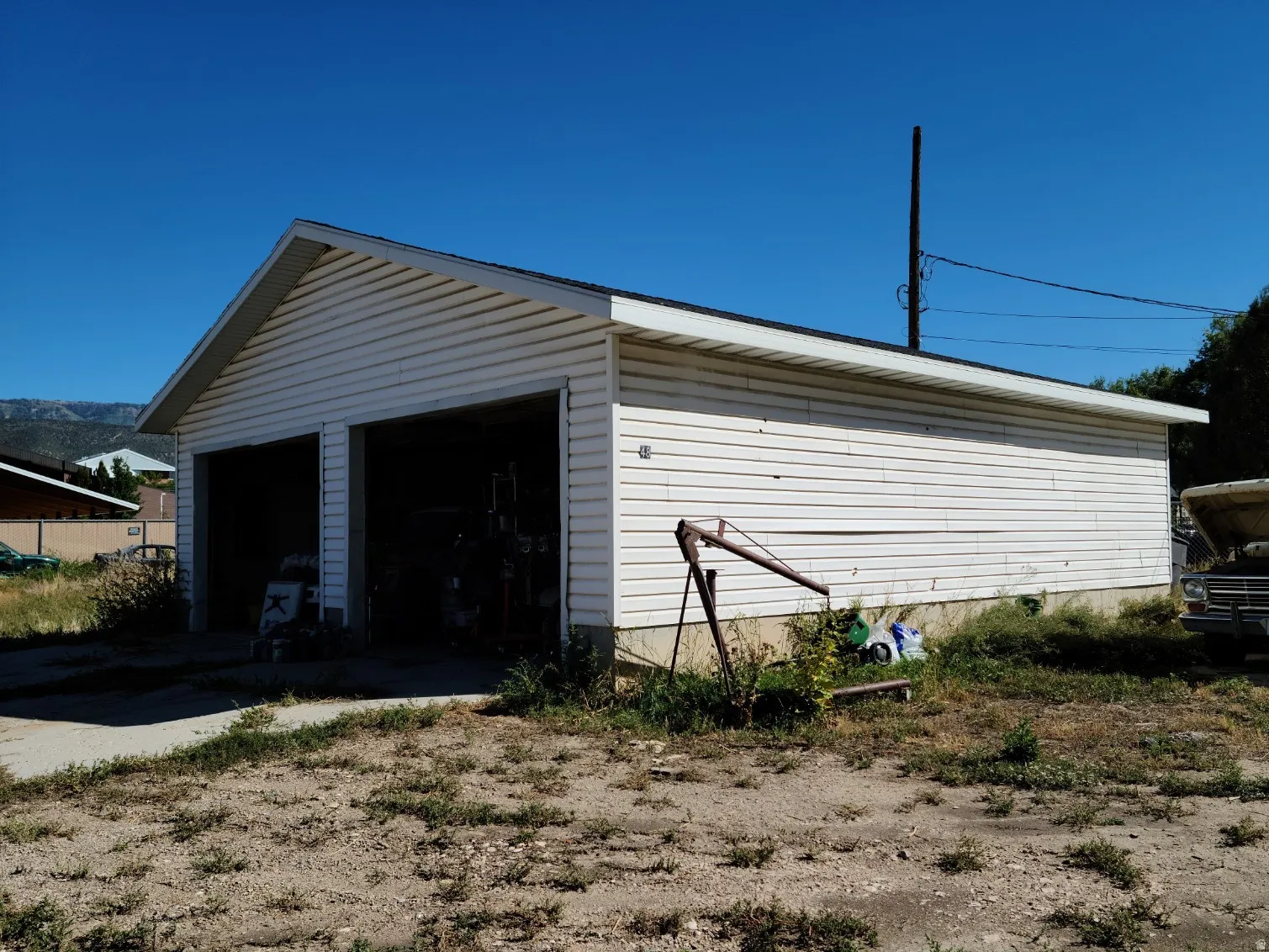 Two-bay detached garage with white siding and a gable roof