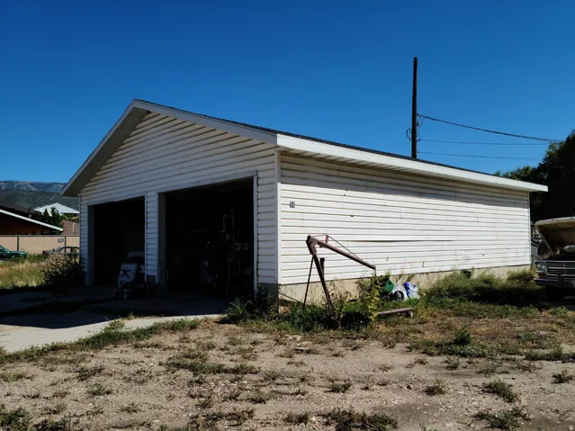 Two-bay detached garage with white siding and a gable roof