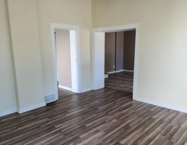 Wood-finish flooring throughout, light-toned wall paint, and white trim