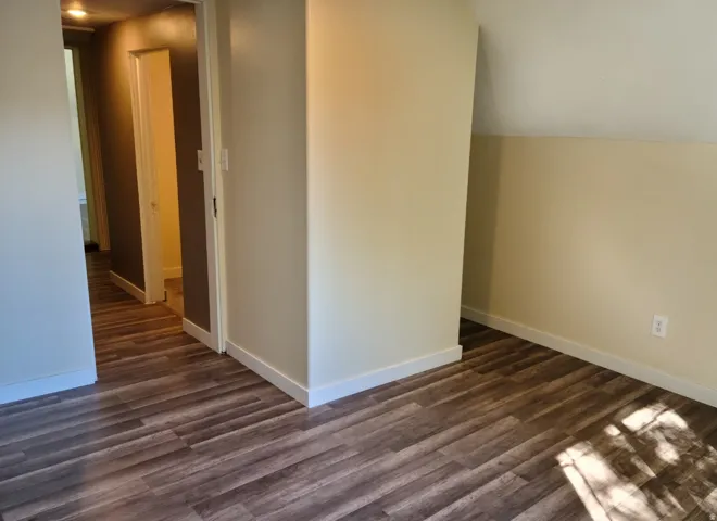 Wood-finish flooring throughout, complemented by light-toned wall finishes and white trim