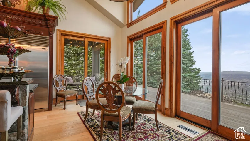Vaulted ceiling, wood flooring, built-in stainless steel SubZero  refrigerator, multiple full-height glass patio doors, and a wood-paneled wall for dramatic valley views.