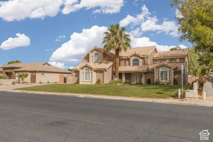 Mediterranean-style residence featuring a stucco exterior, multiple arched windows, and a tile roof