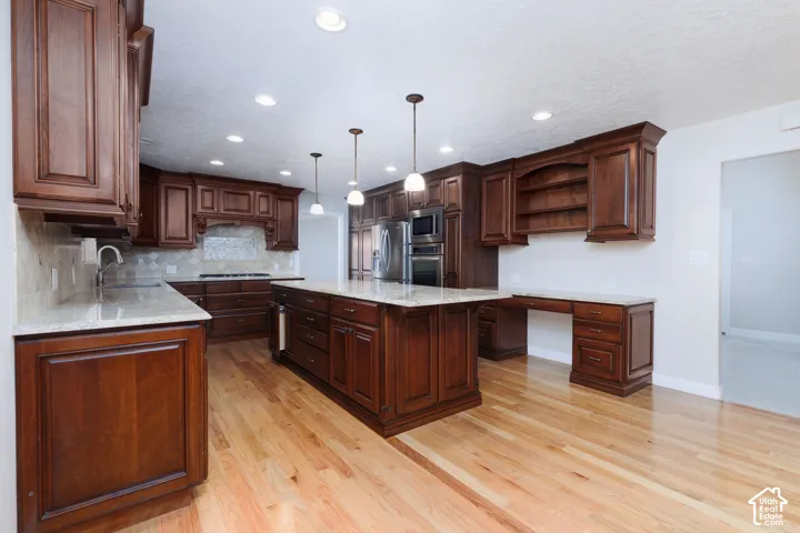 Wood-finish flooring throughout the kitchen with recessed lighting