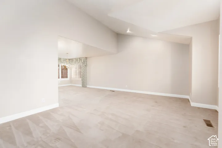 Vaulted ceilings, recessed lighting, and neutral wall tones
