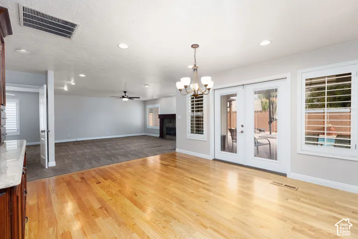 Hardwood flooring, recessed lighting, double glass patio doors, window shutters, and a chandelier