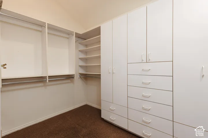 Custom closet system with white cabinetry, integrated drawers, and ample shelving