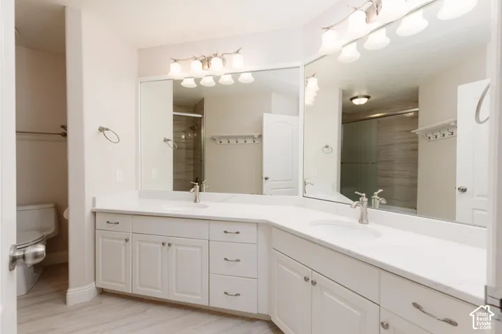 Dual vanity with white cabinetry, white countertops, and integrated sinks