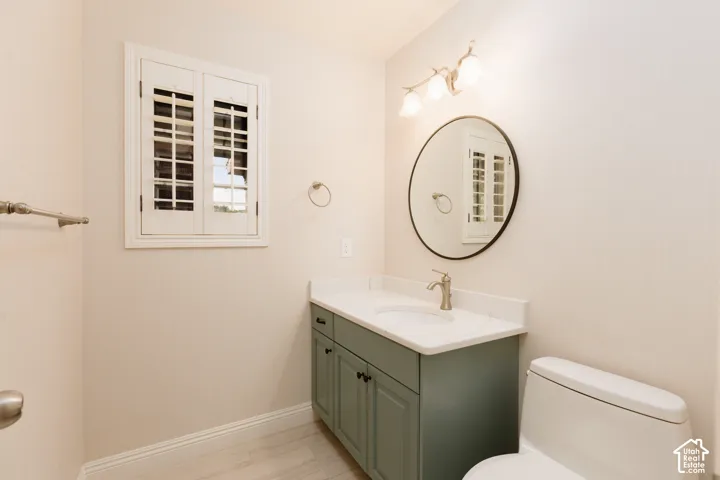 White shaker-style window shutters, vanity with stone countertop, vessel sink, and brushed nickel faucet