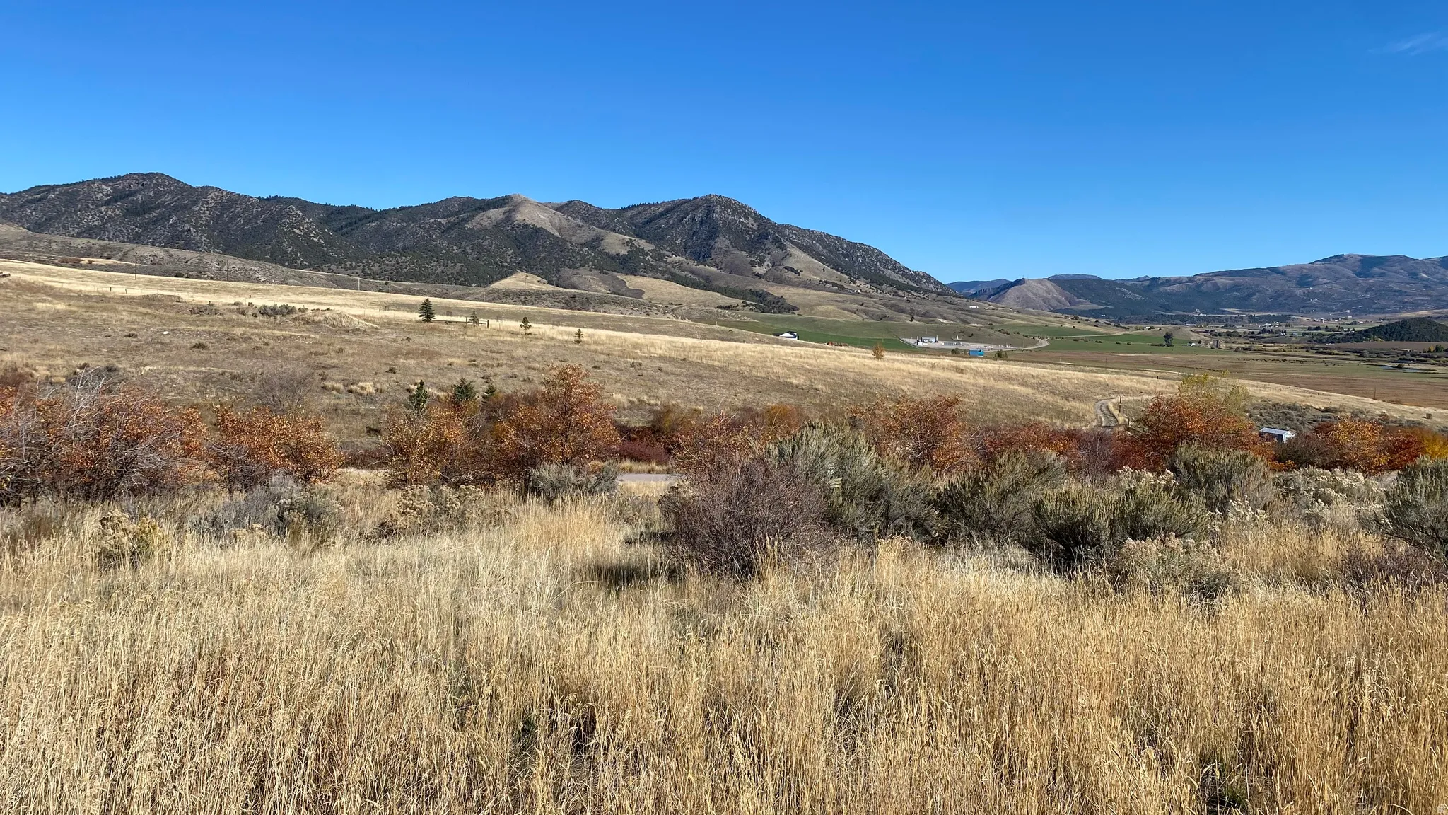 Expansive natural landscape featuring rolling hills and distant mountains