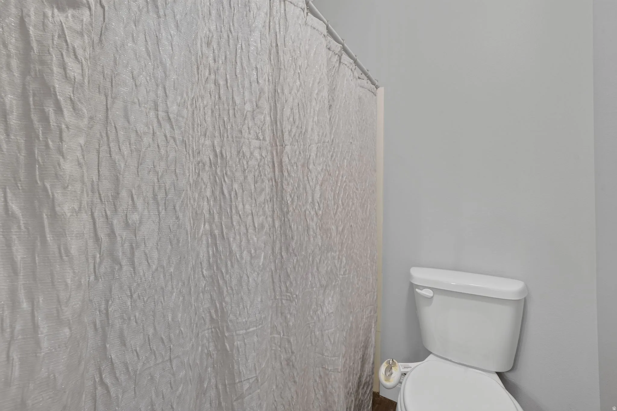 White toilet with a toilet paper holder