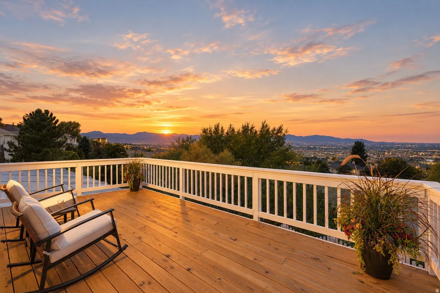 Expansive outdoor deck featuring wood-finish flooring, white railing, and distant mountain scenery