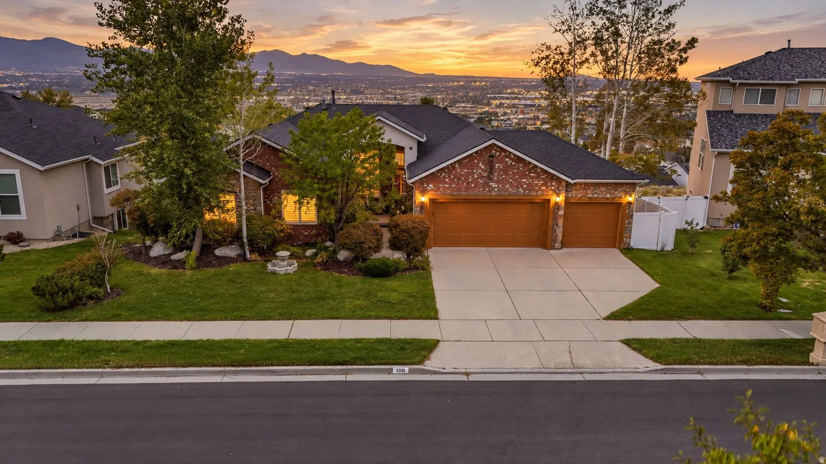 Brick exterior with a stone accent facade, dual garage doors, and a concrete driveway