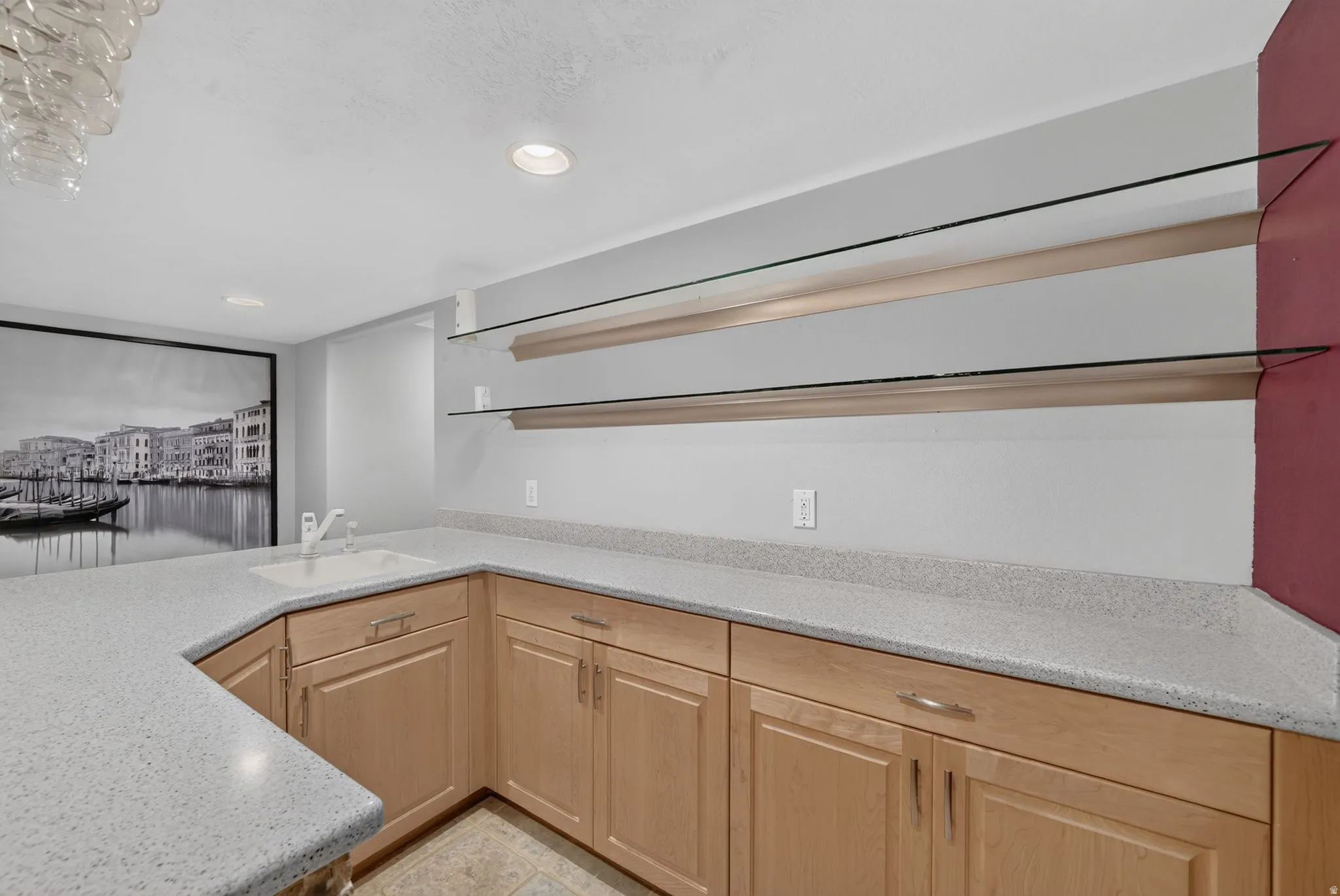 Corner wet bar with light wood cabinetry and light-toned countertops
