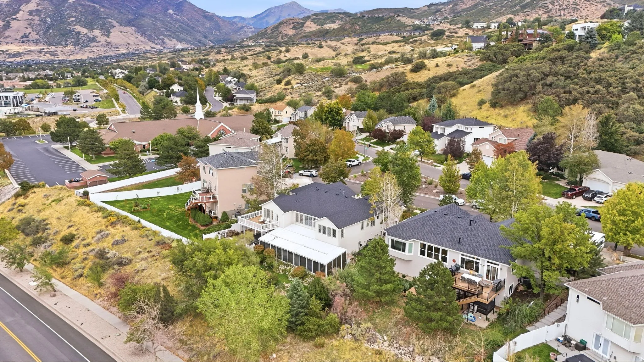 Residential property with a multi-level exterior, an enclosed patio, and a backyard area