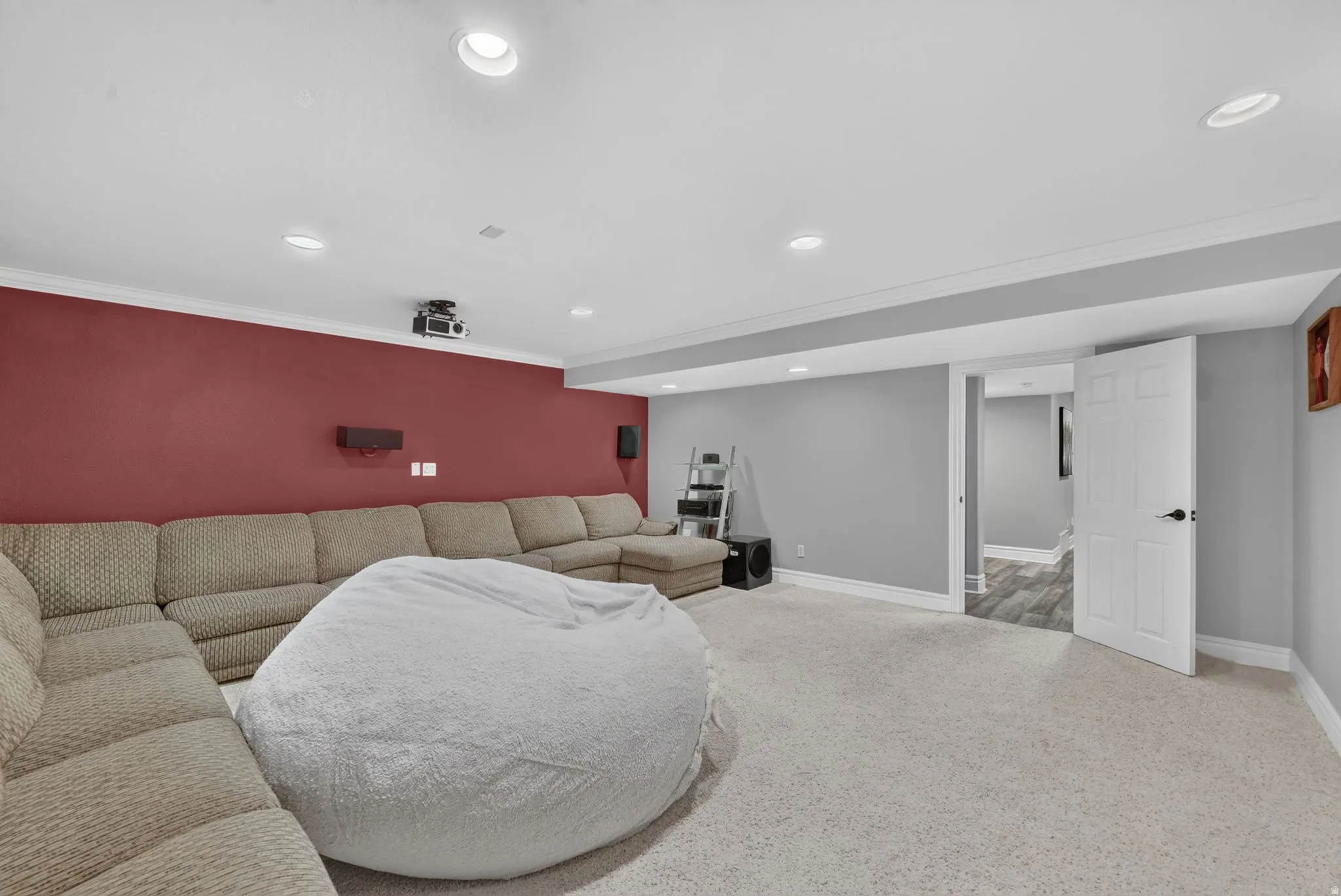 Recessed ceiling lighting, crown molding, two-tone painted walls, and light-colored carpeting