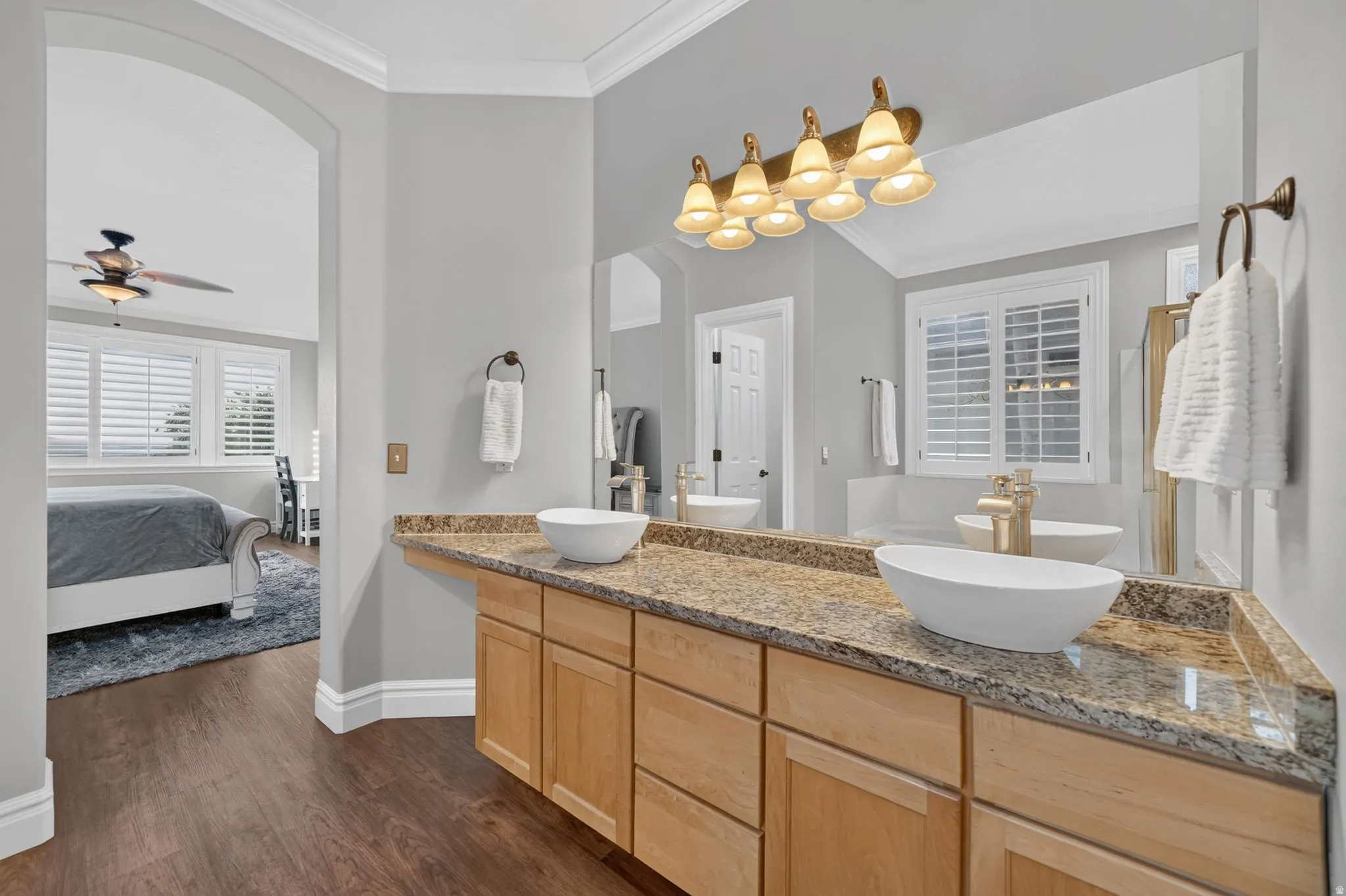 Double vanity with vessel sinks, wood cabinetry, and a granite countertop