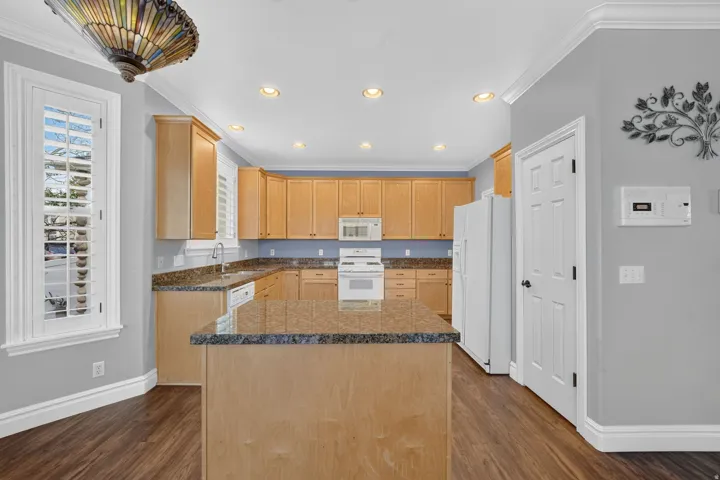 Kitchen featuring wood-finish flooring, recessed lighting, and a center island with a granite countertop