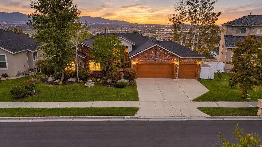 Brick exterior with a stone accent facade, dual garage doors, and a concrete driveway