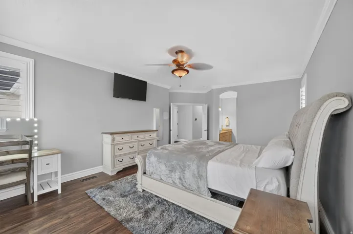 Wood-finish flooring, crown molding, and a ceiling fan with integrated lighting
