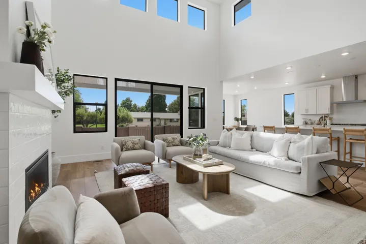Soaring ceilings complemented by a contemporary fireplace with a white tile surround
