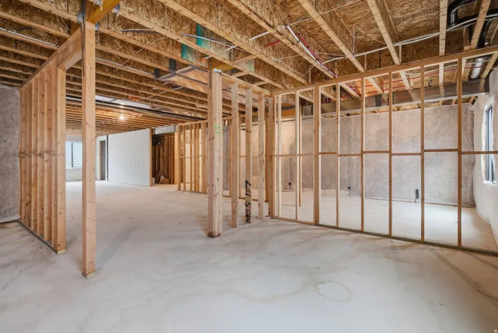 Unfinished basement with exposed wood framing, concrete flooring, and visible ceiling joists