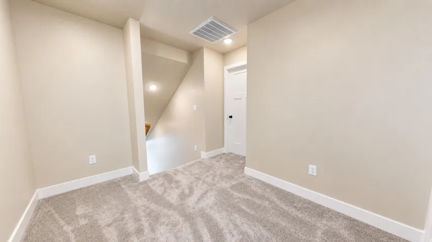 Carpeted flooring, neutral wall tones, recessed lighting, and a white interior door