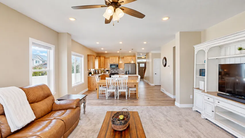 Spacious open-concept layout with carpeted living area and wood-finish flooring