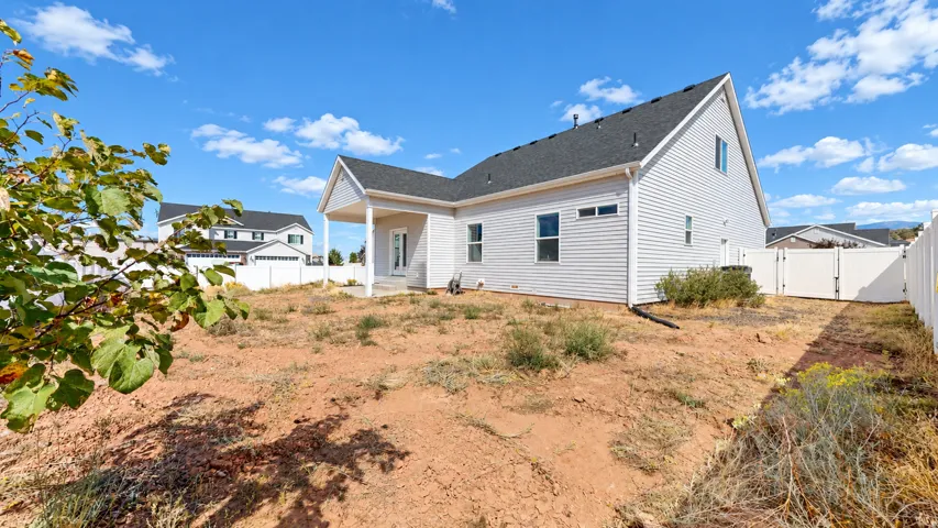 Expansive backyard with a covered patio, vinyl siding, and a privacy fence