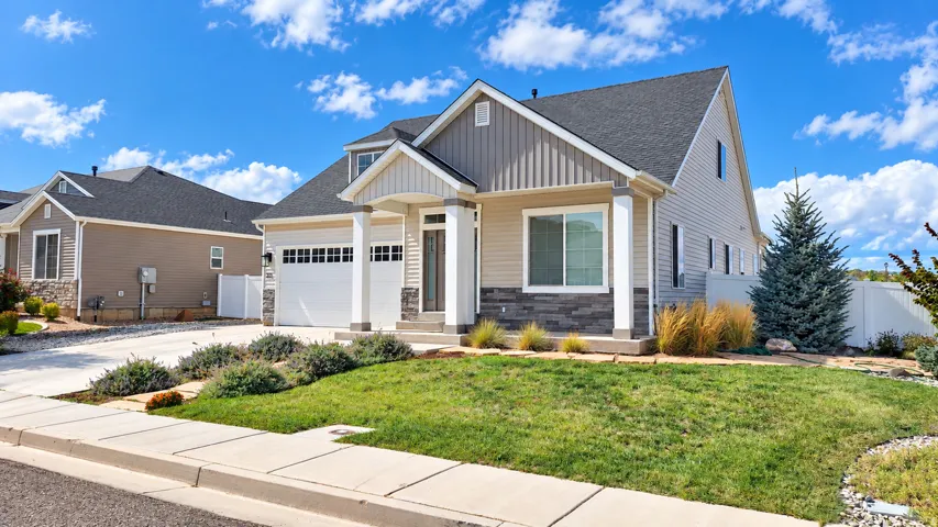 Contemporary exterior with mixed siding and stone accents, a two-car garage, and established landscaping