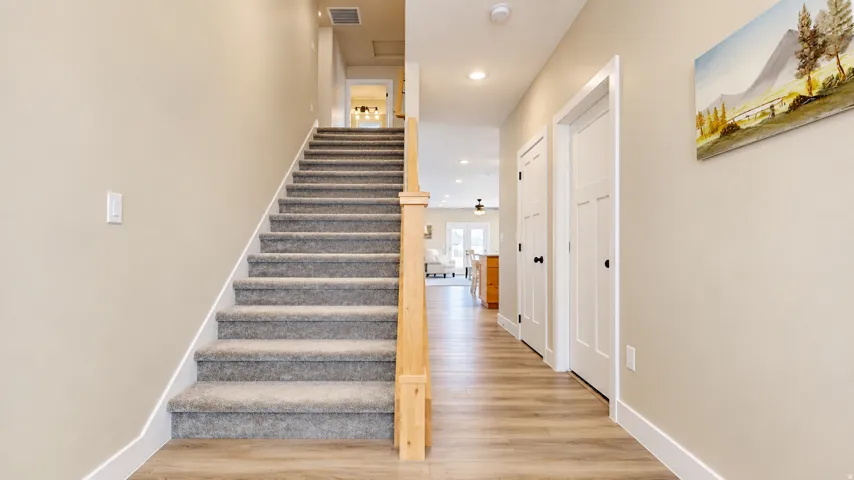 Carpeted staircase with natural wood newel post