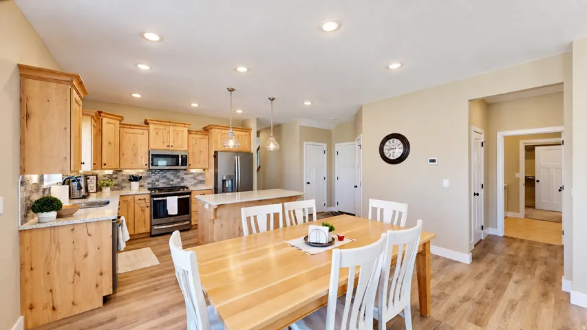 Kitchen featuring wood-finish flooring, recessed lighting, wood cabinetry, stainless steel appliances, and a kitchen island with pendant lighting