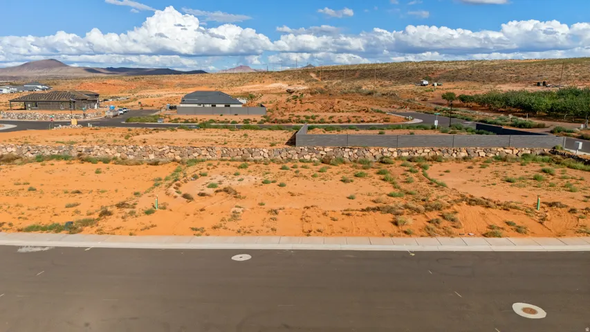 Paved road frontage, established curb, mountainous backdrop, and undeveloped land