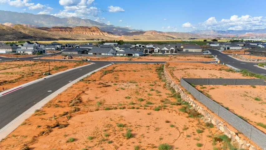 Paved streets with concrete curbing, partially developed residential area, and distant mountainous landscape
